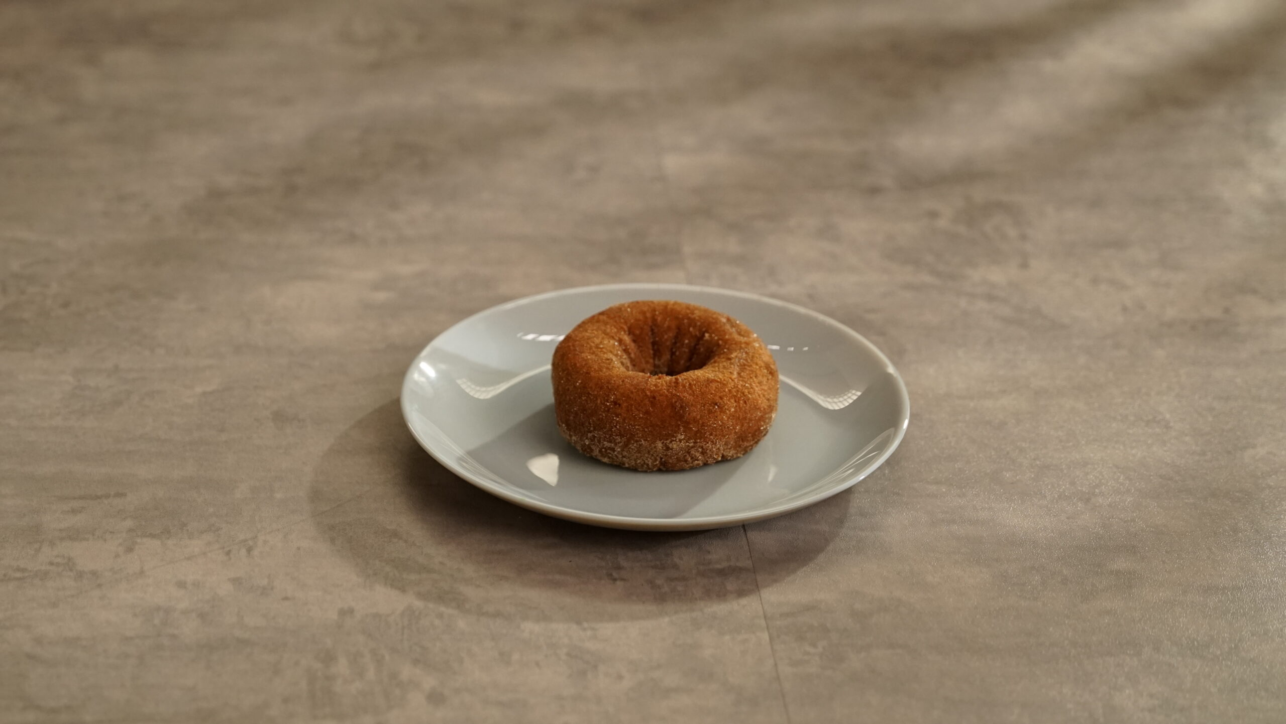 Lifestyle shot of CINNAMON SUGARED PUMPKIN CAKE DONUT