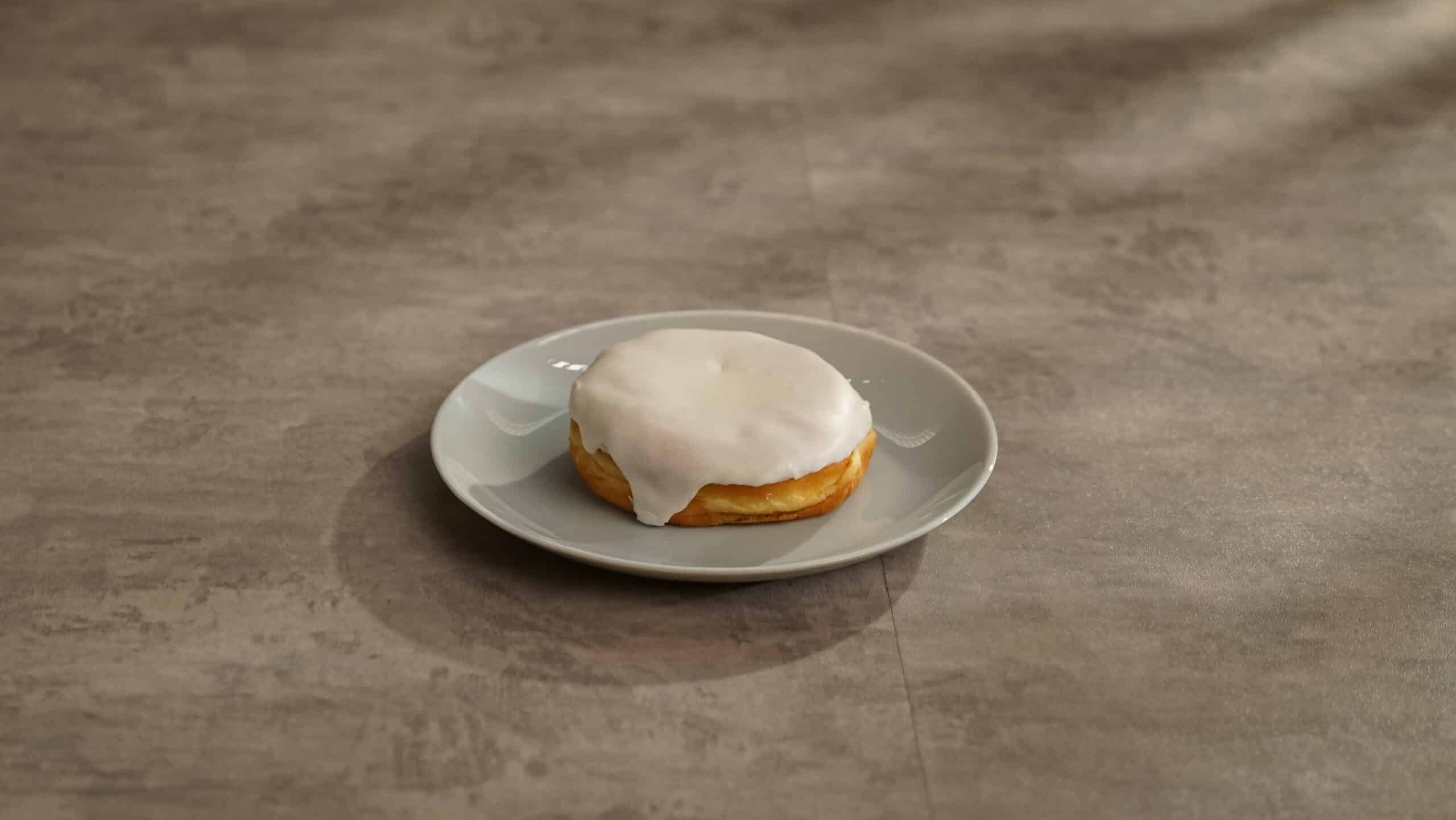 Lifestyle shot of VANILLA ICED RASPBERRY FILLED BISMARCK 4.0 OZ